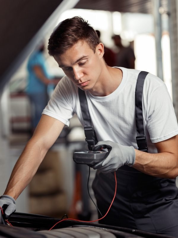 an-attractive-car-mechanic-is-checking-the-results-of-his-work-at-a-car-repair-service.jpg